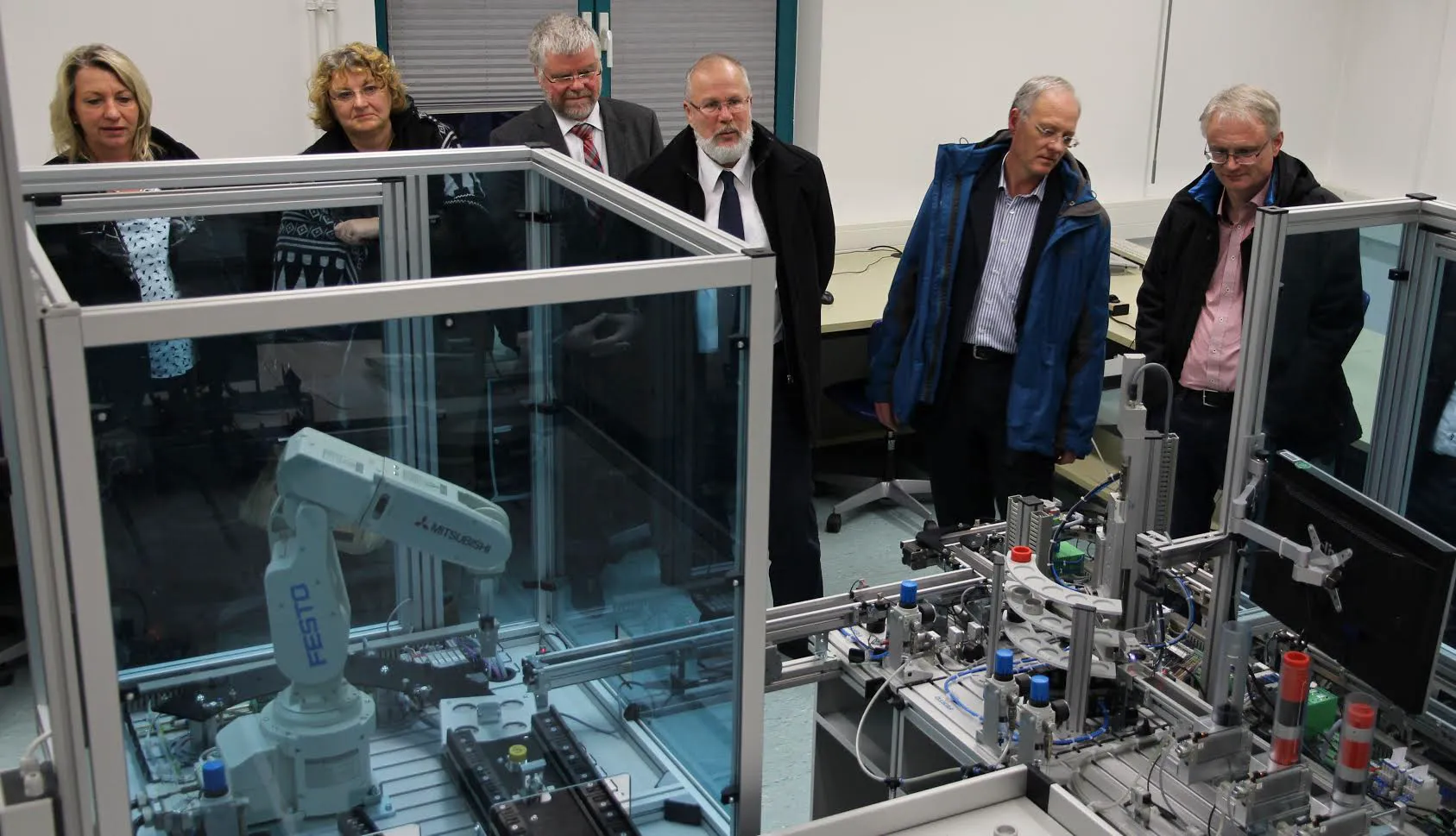 Im Labor für Steuerungstechnik und Robotik bekamen die Gäste einen Eindruck davon, wie die Fabrik der Zukunft aussieht. Von links: Evelyn Benner (Theodor-Heuss-Schule Wetzlar),   Ulla Carina Reitz  (Wilhelm-Knapp-Schule Weilburg), Jörg Keller (Theo-Koch-Schule Grünberg),  Werner Nissel (Ricarda-Huch-Schule Gießen),  Dirk Hölscher (Liebigschule Gießen),  Matthias Storck (Landgraf-Ludwigs-Gymnasium Gießen). Foto: TH Mittelhessen/Armin Eikenberg